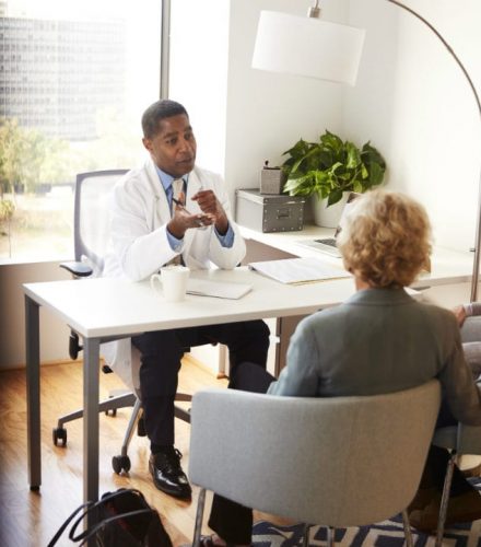 A doctor in a meeting with guests.